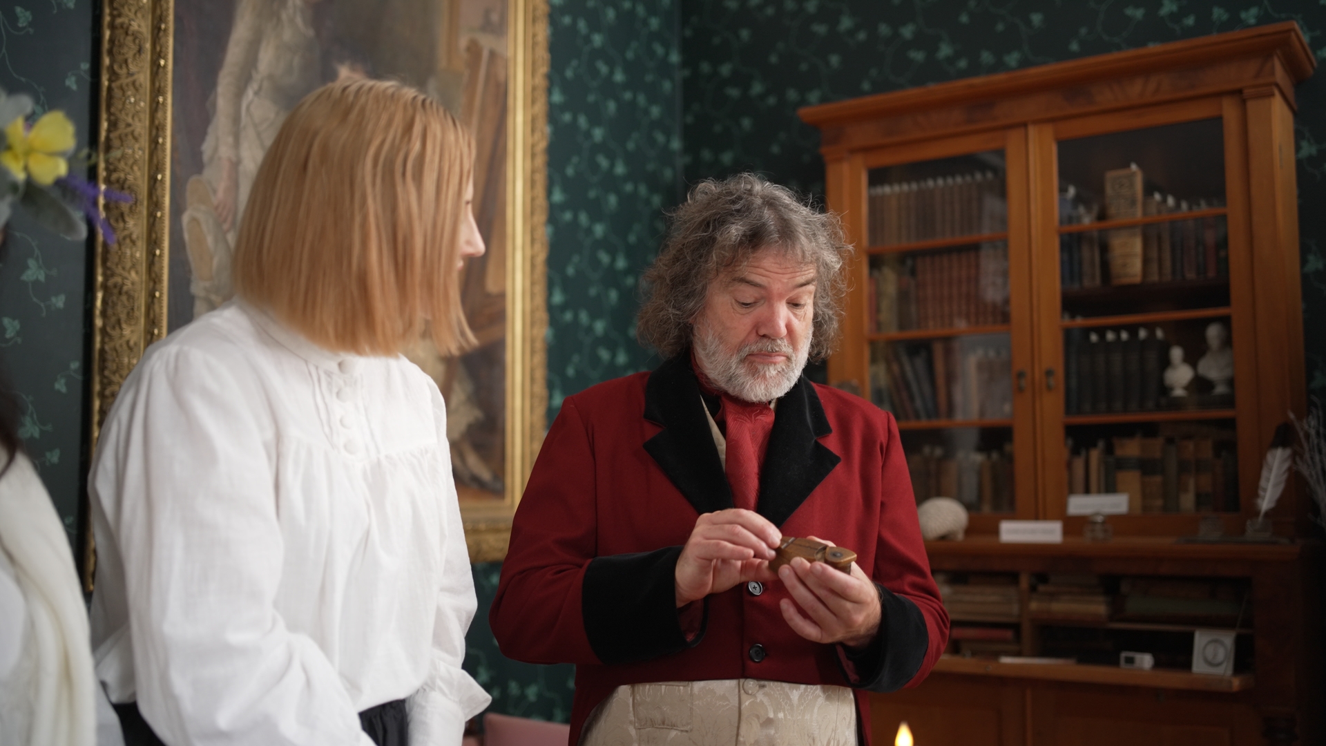 a man and a woman look at curios while dressed in period clothing at the Perth Museum Matheson house experience in Perth ontario