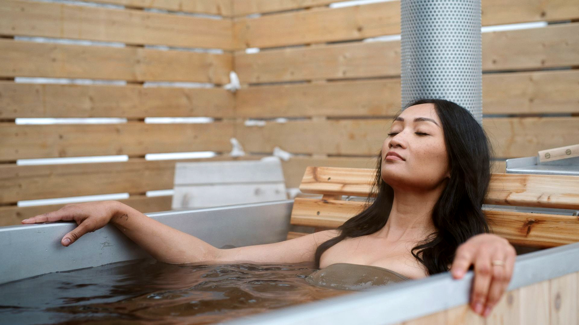 thumbnail for tourism and travel videos, showing an asian woman relaxing in a hot tub at a stylish resort