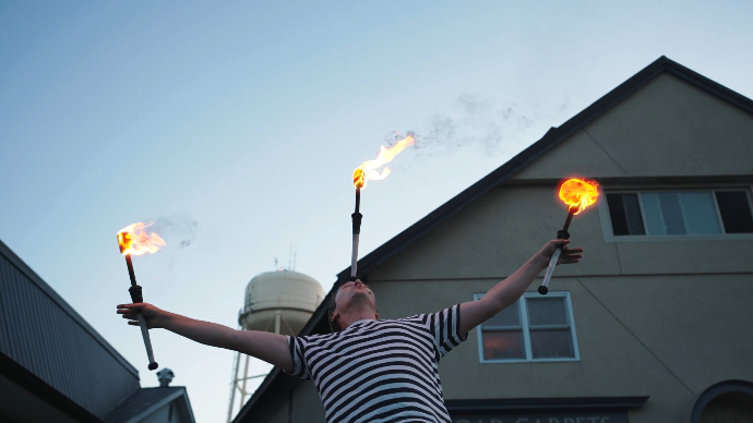 a juggler balances a flaming baton on his nose in downtown Perth, Ontario