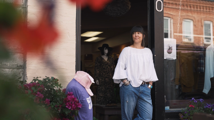 a young fashionable woman stands outside her clothing store in downtown Perth, Ontario, a production still from a video