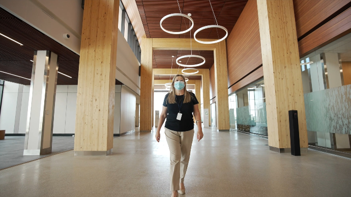 a woman walks down the hallway of carrefour santé d'orleans, taken from mainspring's corporate video for hôpital Montfort