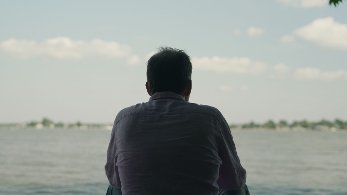 a man sits on the coast of Chesapeake bay in Maryland's eastern shore, production still from mainspring agency's documentary, salted earth