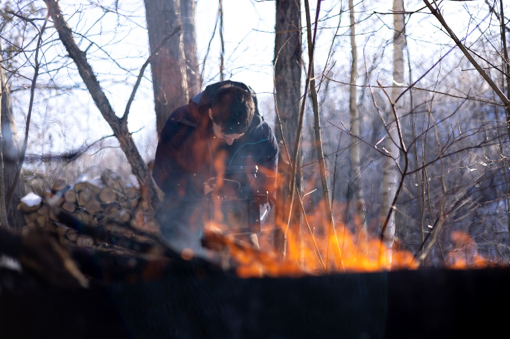 a cinematographer with a matte box and external monitor films a fire in the winter in ontario